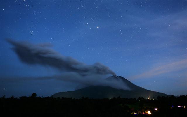 Bức ảnh này được chụp với tốc độ chậm cho thấy núi lửa Sinabung phun trọ bụi lên bầu trời, nhìn từ Tiga Pancur, Bắc Sumatra