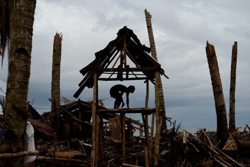Một nạn nhân của cơn bão ở Philippines xây dựng lại túp lều của mình ở Basay
