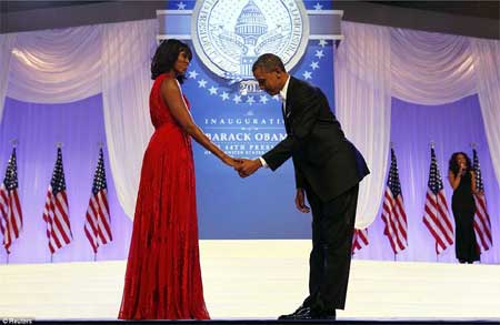 Tổng thống Barack Obama cúi mình trước đệ nhất phu nhân Michelle Obama trong khi ca sĩ Jennifer Hudson (phải) biểu diễn đằng sau họ tại lễ nhậm chức ở Washington vào ngày 21/1.