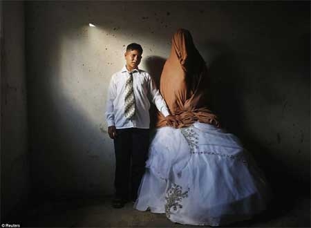 Chú rể Ahmed Soboh, 15 tuổi, và cô dâu Tala, 14 tuổi, đều là người Palestine, đang đứng trong nhà của Tala tại hôn lễ của cả hai ở Beit Lahiya, gần biên giới với Israel và Dải Gaza hôm 24/9.