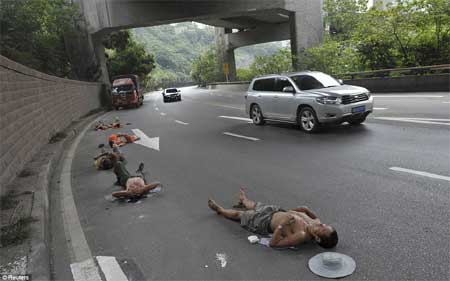 Người lao động ngủ trưa trên đường trong khi xe cô vẫn lưu thông ở Trùng Khánh, Trung Quốc vào 23/7.