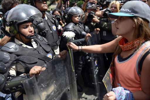 Một sinh viên tặng hoa cho cảnh sát trong một cuộc biểu tình phản đối tại Caracas - Venezuela.