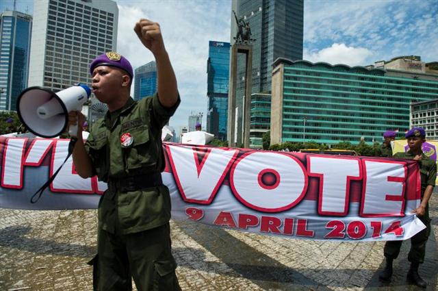 Một người lính dự bị của vũ trang Indonesia đọc diển văn trước đám đông đi bỏ phiếu cho cuộc bầu cử quốc hội tại Jakarta