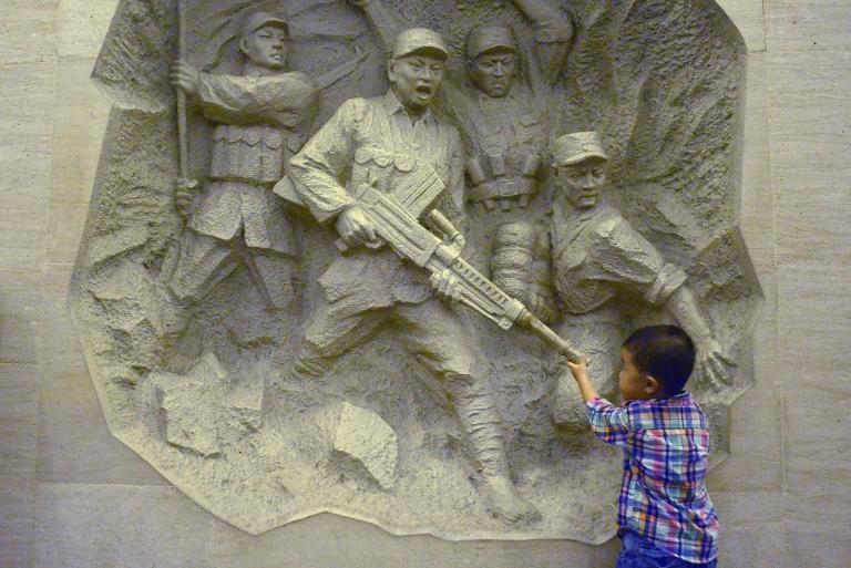 Một cậu bé đang tò mò trước bức tượng tại bảo tàng chiến tranh Lugouqiao, ở phía tây Bắc Kinh, vào dịp kỷ niệm 77 năm sự kiện Marco Polo Bridge