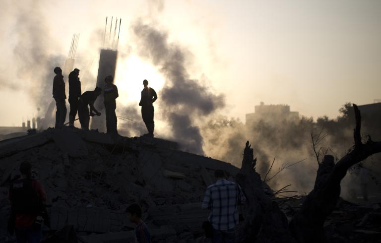 Người Palestine kiểm tra thiệt hại sai một cuộc tấn công quân sự của Israel tại thành phố Gaza