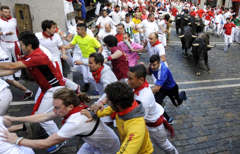 Người tham gia lễ hội San Fermin ở Pamplona, ​​miền bắc Tây Ban Nha đang tháo chạy tán loạn khi đàn bò được thả ra trên phố