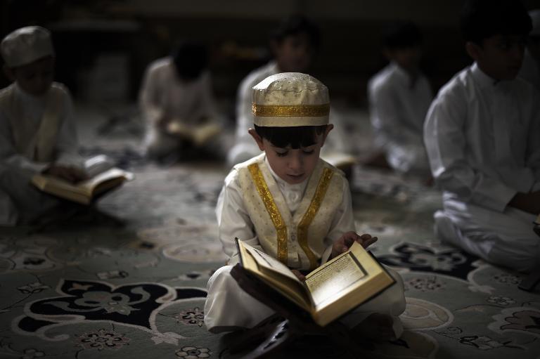 Một cậu bé Hồi giáo Shiite Bahrain đọc kinh Koran, cuốn sách thánh của Hồi giáo, trong tháng ăn chay Ramadan tại nhà thờ Hồi giáo ở làng Sanabis, phía tây của Thủ đô Manama