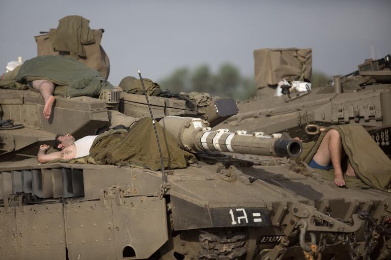 Binh sĩ Israel ngủ ngay trên những chiếc xe tăng của họ tại khu vực triển khai quân sự gần biên giới của Israel với Dải Gaza