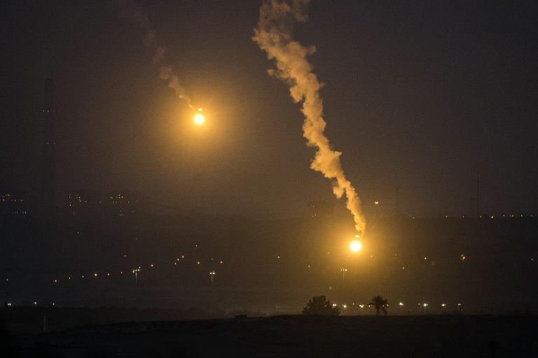 Một bức tranh được chụp ở biên giới Gaza khi quân đội Israel bắn pháo sáng trên bầu trời dải Gaza