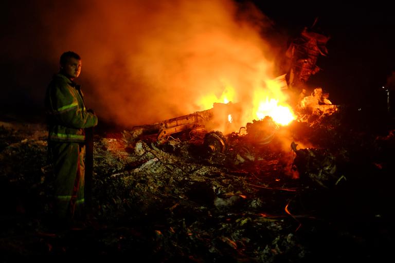 Một lính cứu hỏa cạnh ngọn lửa giữa đống đổ nát của chiếc máy bay Malaysia chở 298 người  từ Amsterdam đến Kuala Lumpur sau khi bị rơi gần thị trấn Shaktarsk, Ukraina