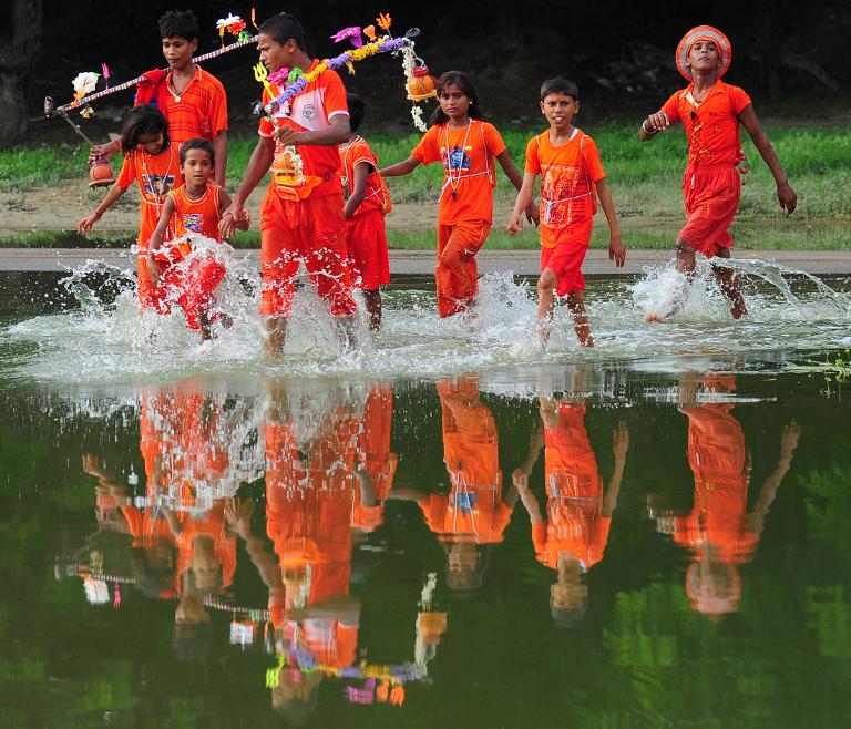 Những đứa trẻ đang đi lấy nước trên sông Hằng trong tháng lễ Shravan ở Ấn Độ