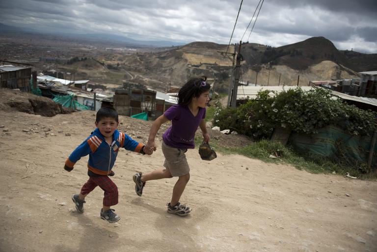 Trẻ em chạy dọc theo một con đường phía ngoài khu ổ chuột ở Soacha, ngoại ô Bogota, Colombia