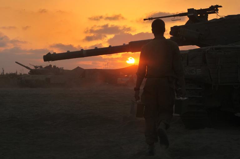 Một binh sĩ Israel đứng cạnh chiếc xe tăng ở vùng biên giới giữa Israel và Dải Gaza do quân Hamas kiểm soát