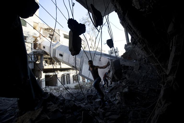 Một người đàn ông Palestine kiểm tra đồng đổ nát của một nhà thờ Hồi giáo bị phá hủy tại thành phố Gaza