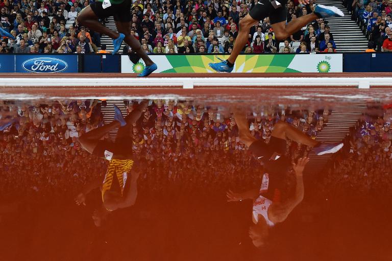 Bóng 2 VĐV phản chiếu xuống một vũng nước cạnh đường pit trong nội dung thi 200 m nam tại giải Commonwealth Games 2014 ở Glasgow, Scotland