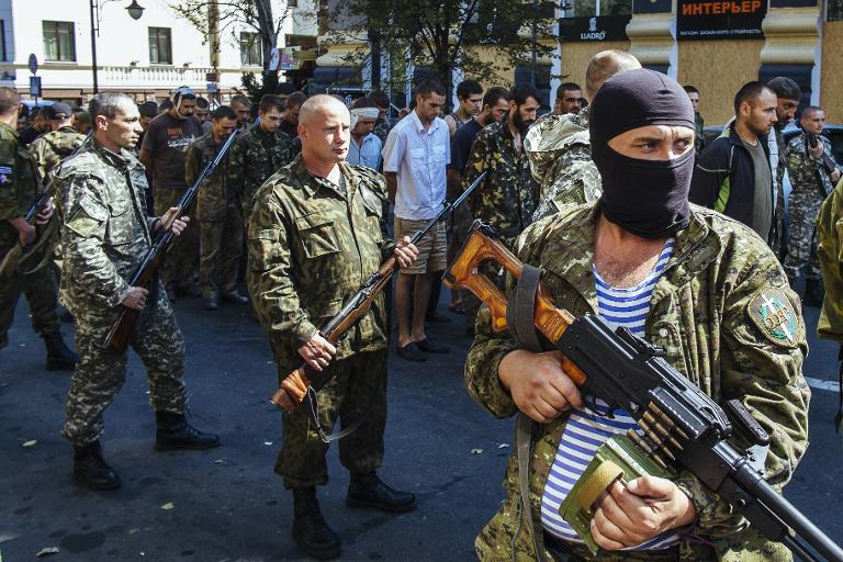 Các tay súng của lực lượng thân Nga canh chừng hàng dài các binh lính Ukrain bị bắt