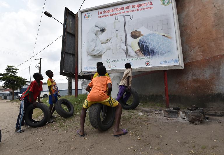 Những đứa trẻ nhìn chăm chú vào tấm áp phích tại Abidjan, Bờ Biển Ngà cảnh báo về sự nguy hiểm của Virust Ebola
