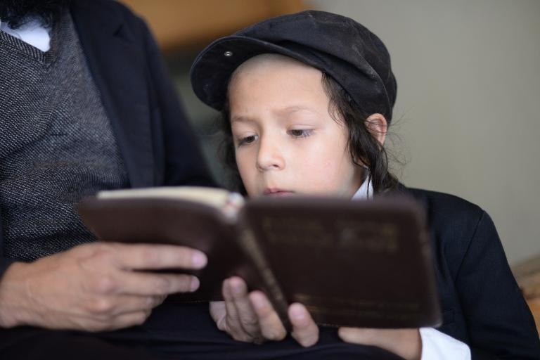 Một đứa trẻ Do Thái đọc kinh Torah với cha mình tại thành phố Guatemala