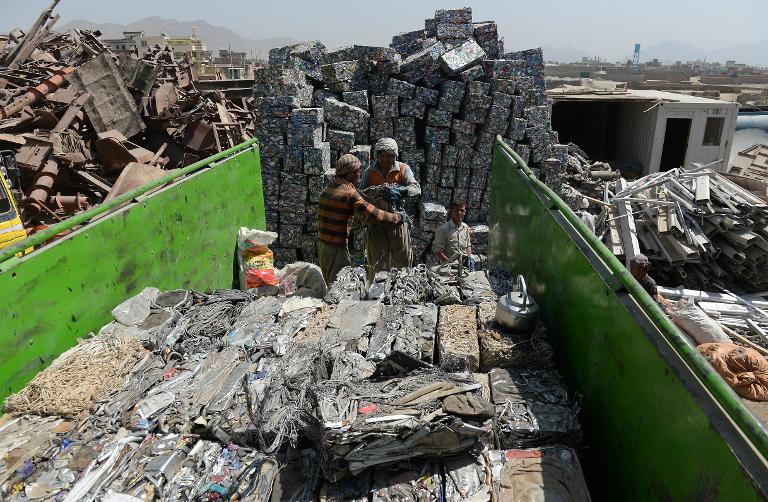 Người lao động nghèo Afghanistan đang thu gom rác thải tái chế lên thùng xe tải tại một bãi phế liệu ở vùng ngoại ô thủ đô Kabul