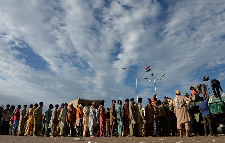 Những người Pakistan xếp hàng dài tại một điểm phân phối lương thực trong một cuộc biểu tình chống chính phủ ở phía trước tòa nhà quốc hội Islamabad