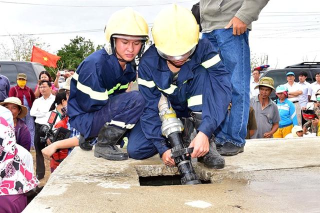 Cán bộ Cảnh sát PCCC của tỉnh Ninh Thuận đang bơm nước sạch vào bể chứa của bà con