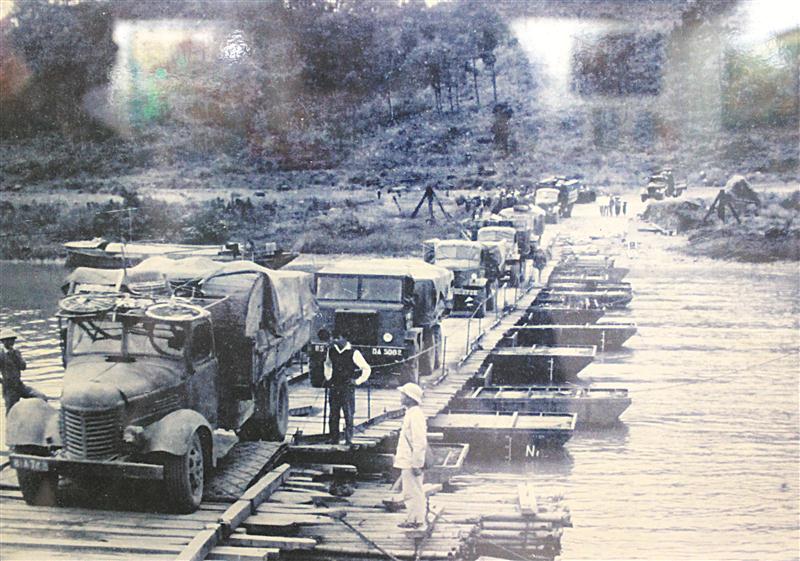 Lực lượng Công an Nghệ An hướng dẫn ôtô chở hàng hoá                      và vũ khí vào                     chiến trường miền Nam                       qua cầu Cấm,                    huyện Nghi Lộc                         vào năm 1965 - Ảnh tư liệu