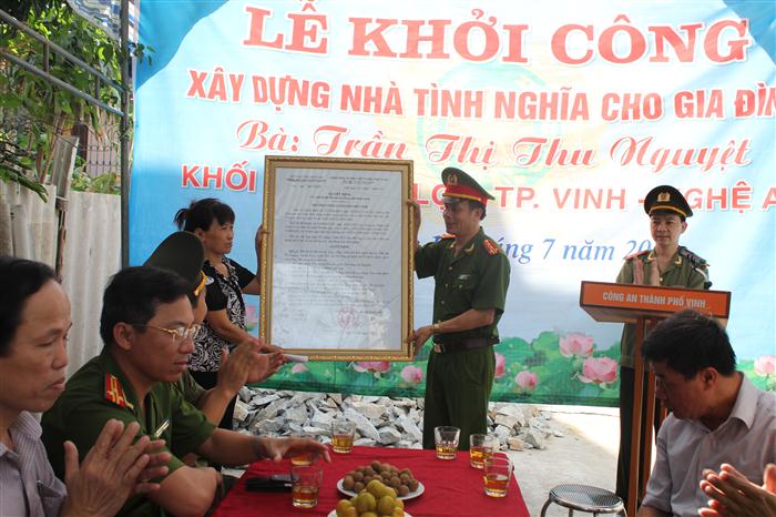 Đại tá Trần Ngọc Tú, Trưởng công an thành phố Vinh trao quyết định phê duyệt đầu tư xây dựng nhà tình nghĩa cho chị Trần Thị Thu Nguyệt