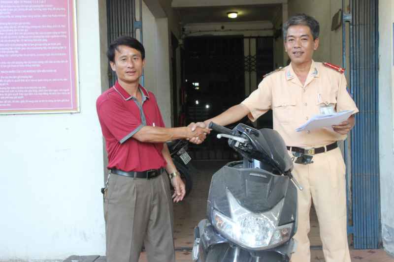 CSGT công an thành phố Vinh trao trả chiếc xe máy cho đại diện gia đình chị 