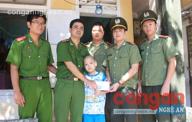 Đại diện Đoàn TNCS Hồ Chí Minh Công an tỉnh và Công an huyện Đô Lương trao số tiền 5 triệu đồng hỗ trợ gia đình đồng chí Nguyễn Thành Công