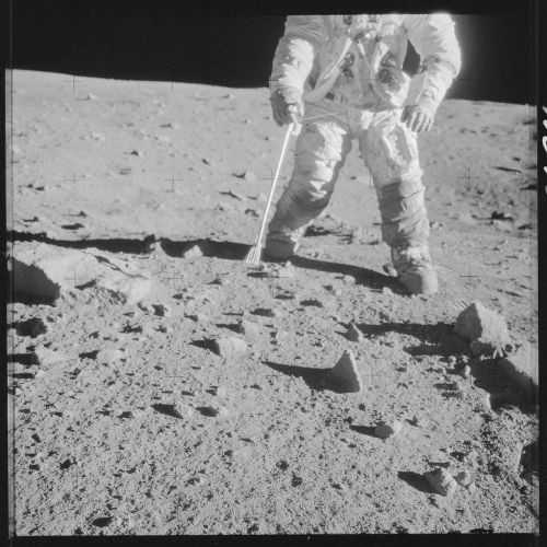 Phi hành gia của Apollo 12 đang lấy mẫu vật đất Mặt trăng để xét nghiệm.