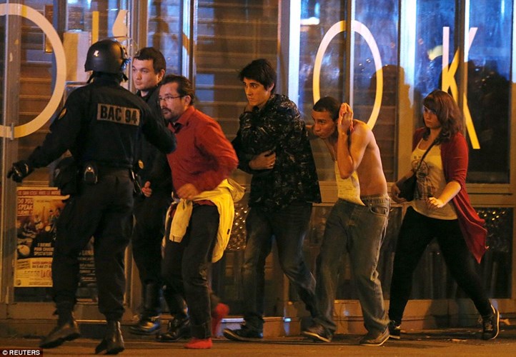 Cảnh sát giải cứu các con tin ra khỏi nhà hát Bataclan, một người đàn ông trong số đó bị thương ở đầu. (ảnh: Reuters).