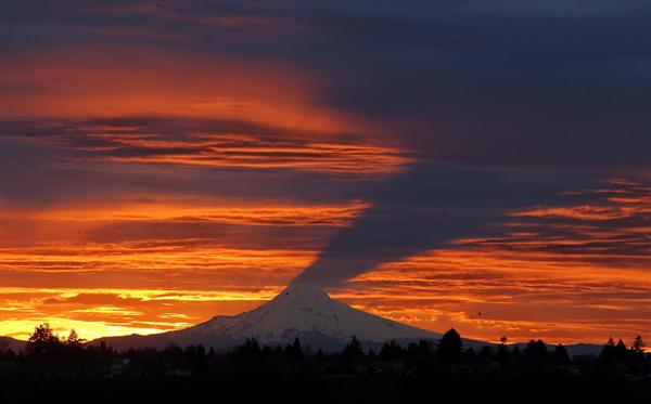 Mặt trời mọc tạo bóng của ngọn núi Hood in lên những đám mây ở Portland, Oregon, 24/02/2016.