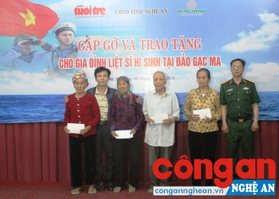 Cựu binh Lê Hữu Thảo (thứ 2 từ trái sang) tặng quà cho thân nhân các liệt sĩ Gạc Ma