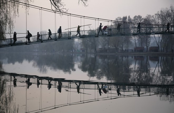 Người dân đi lại trên cây cầu treo bắc qua sông Pothong ở thủ đô Bình Nhưỡng. Đây là con sông lớn thứ 2 chảy qua thủ đô Triều Tiên.