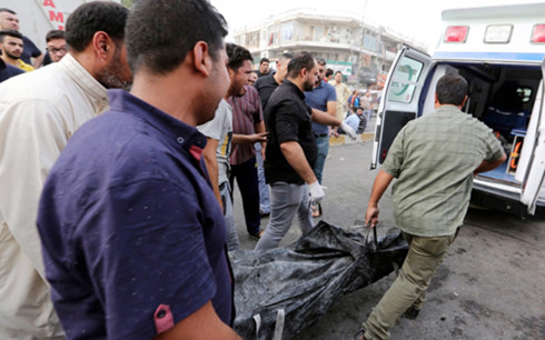 Lực lượng chức năng Iraq thu thập các thi thể trong vụ đánh bom. (Ảnh: EPA)
