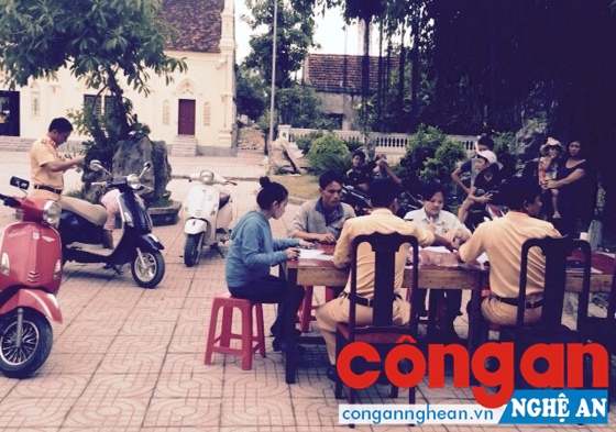  CBCS Đội CSGT Công an huyện Quỳnh Lưu làm thủ tục đăng ký môtô điện, xe máy điện cho người dân.