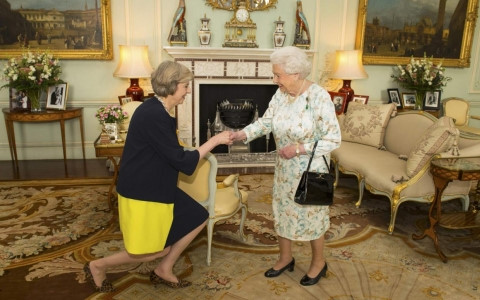 Bà Theresa May (trái) thực hiện nghi thức hôn tay Nữ hoàng Anh trước khi chính thức trở thành Thủ tướng mới. Ảnh AP