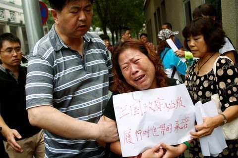 Thân nhân một hành khách đi trên chuyến bay Malaysia MH370 mất tích cách đây 2 năm biểu tình trước trụ sở Bộ ngoại giao Trung Quốc ở Bắc Kinh hôm 29-7 đòi câu trả lời từ chính phủ về số phận người thân của họ  - Ảnh: Reuters