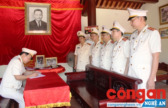 Đại tá Nguyễn Xuân Thiêm ghi cảm tưởng vào sổ lưu niệm tại Nhà tưởng niệm cố Bộ trưởng Bộ Công an Trần Quốc Hoàn ở xã Nam Trung, huyện Nam Đàn 