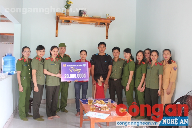 Thiếu tá Nguyễn Việt Hà, Chủ tịch Hội phụ nữ Công an tỉnh trao tiền hỗ trợ của Hội phụ nữ Công an tỉnh cho vợ chồng chị Thủy