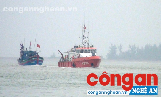 Tàu cứu hộ Hải đội 2, BĐBP Nghệ An đang lai dắt tàu bị nạn của ngư dân vào bờ