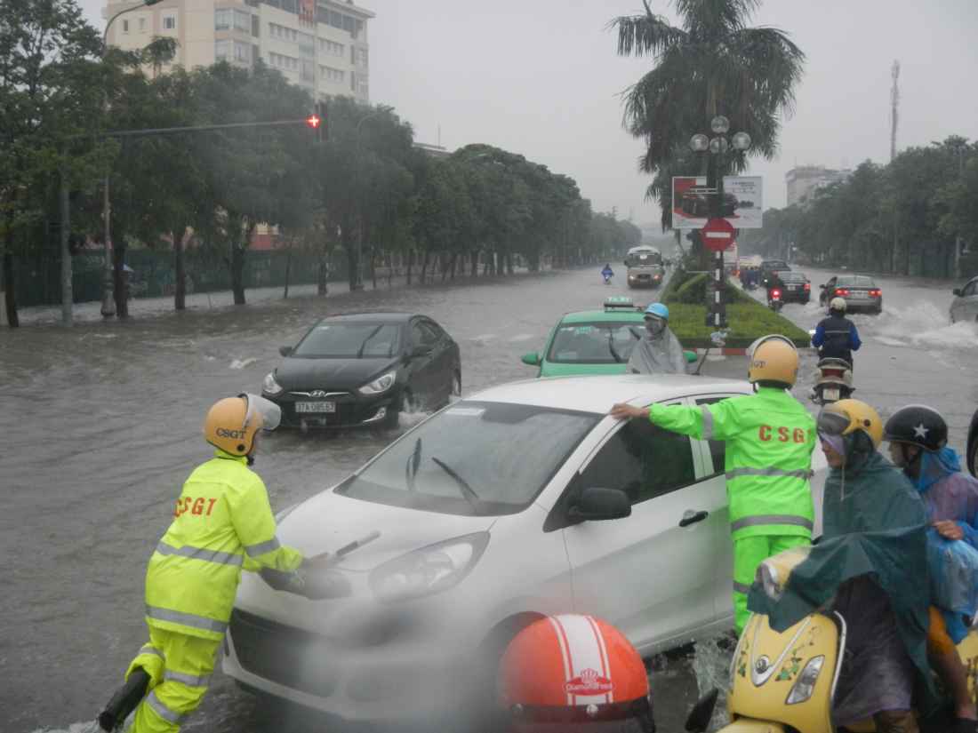 CSGT Công an Nghệ An giúp người đẩy ô tô chết máy ra khỏi nơi ngập nước. Ảnh: Bình Nguyên