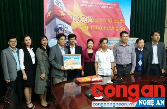 Anh Nguyễn Quốc Đạt, Phó Giám đốc Trung tâm Bồi dưỡng chính trị huyện Nghi Lộc (đứng thứ 5 từ trái sang) trao 1.020 lá cờ Tổ quốc cho lãnh đạo Trường Đại học Sư phạm Huế