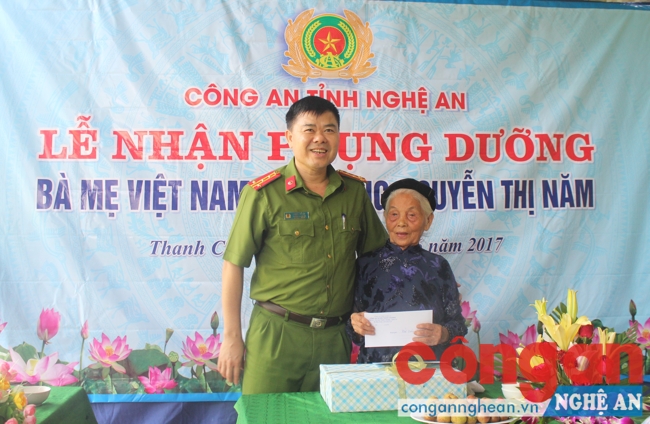 Đồng chí Đại tá Lương Thế Lộc, Trưởng Công an huyện Thanh Chương tặng quà cho mẹ Nguyễn Thị Năm