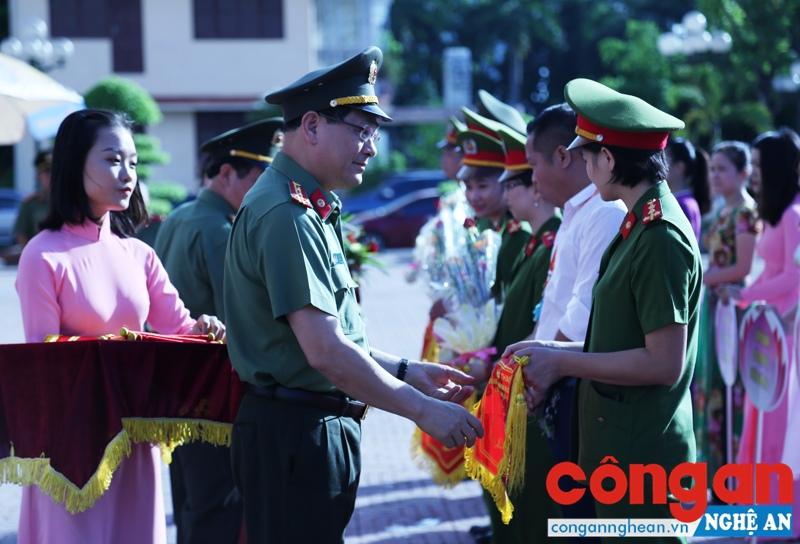 Đồng chí Đại tá Nguyễn Hữu Cầu - Giám đốc Công an tỉnh Nghệ An trao cờ lưu niệm cho các đội tham gia Hội thao.