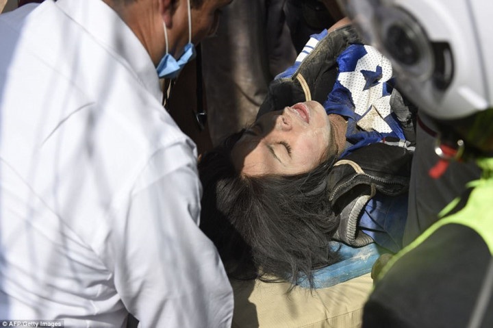 Một người phụ nữ được đưa ra khỏi đống đổ nát. Ảnh: AFP./.