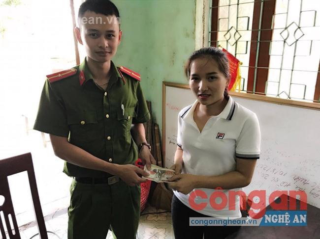 Thiếu úy Nguyễn Văn Lập, cán bộ Đội Điều tra Tổng hợp trao trả số tiền bị mất                                       cho chị Nguyễn Thị Hồng Giang