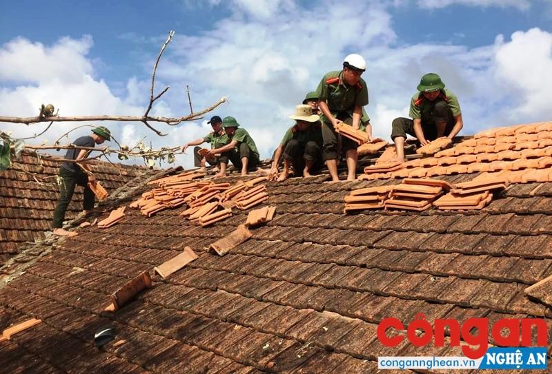 Cán bộ, chiến sỹ Công an tỉnh Hà Tĩnh giúp dân lợp lại mái nhà