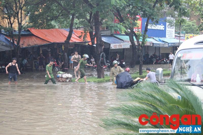 Lực lượng CSTT thành phố Vinh giúp người dân có xe bị nước cuốn