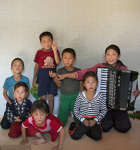 Các cháu bé Triều Tiên thích thú tạo dáng chụp ảnh với phong cầm